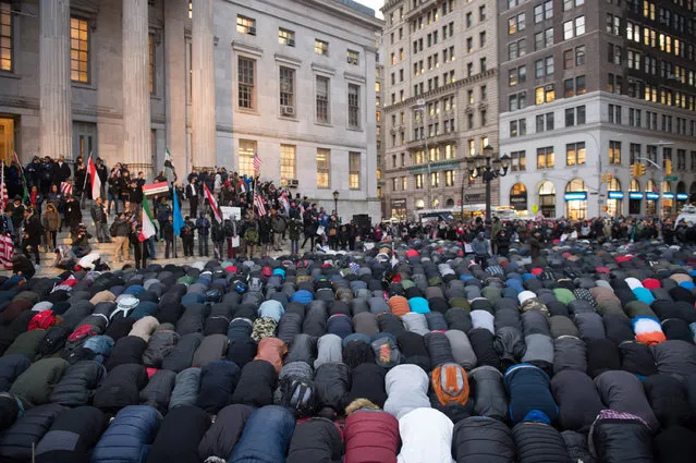 People gather for evening prayer at a rally at Brooklyn Borough Hall as Yemeni bodega and grocery-stores shut down to protest US President Donald Trump's Executive Order banning immigrants and refugees from seven Muslim-majority countries, including Yemen, on February 2, 2017 in New York. (Photo by Bryan R. Smith/AFP Photo)