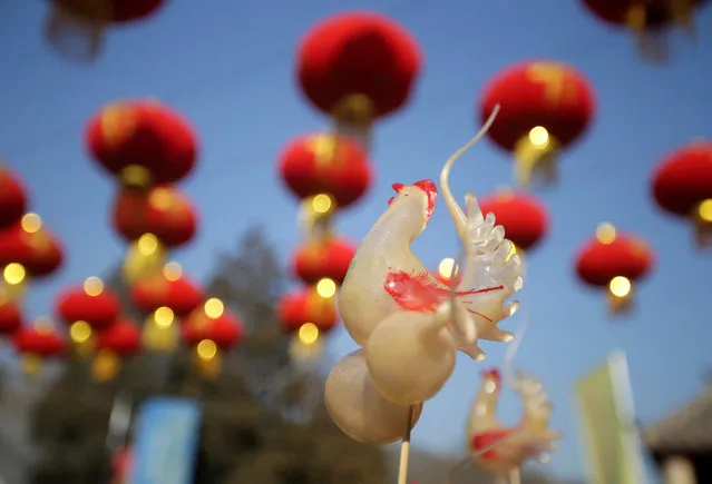 A rooster figure made from sugar using traditional sugar-blowing techniques is displayed on sale during a temple fair at Badachu park as the Chinese Lunar New Year, which welcomes the Year of the Rooster, is celebrated in Beijing, China, January 31, 2017. (Photo by Jason Lee/Reuters)