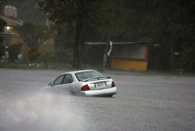 A car is stuck in a flooded street due to Hurricane Rick in Lazaro Cardenas, Mexico, Monday, October 25, 2021. Hurricane Rick roared ashore along Mexico's southern Pacific coast early Monday with winds and heavy rain amid warnings of potential flash floods in the coastal mountains. (Photo by Armando Solis/AP Photo)