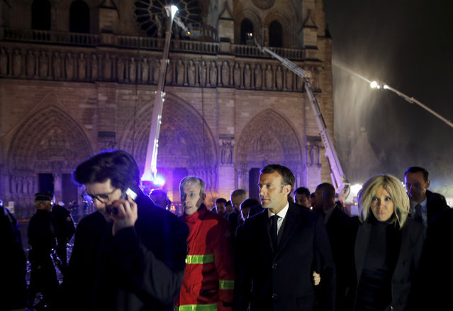 French President Emmanuel Macron, center, and his wife Brigitte walk away from Notre Dame cathedral in Paris, Monday, April 15, 2019. A catastrophic fire engulfed the upper reaches of Paris' soaring Notre Dame Cathedral as it was undergoing renovations Monday, threatening one of the greatest architectural treasures of the Western world as tourists and Parisians looked on aghast from the streets below. (Photo by Philippe Wojazer/Pool via AP Photo)