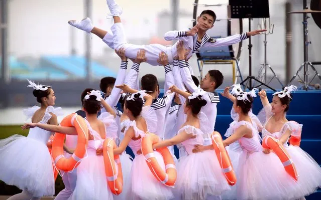 A Chinese military dance troupe performs during a concert featuring Chinese and foreign military bands in Qingdao, Monday, April 22, 2019. Ships from Chinese and foreign navies have gathered in Qingdao for events this week, including a naval parade, to mark the 70th anniversary of the founding of the People's Liberation Army (PLA) Navy. (Photo by Mark Schiefelbein/AP Photo)