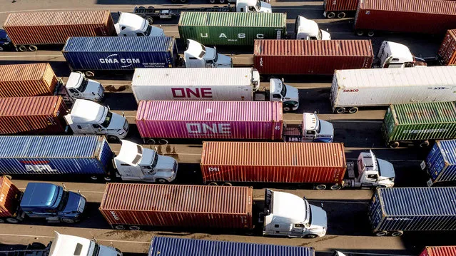Trucks line up to enter a Port of Oakland shipping terminal on Wednesday, November 10, 2021, in Oakland, Calif. Intense demand for products has led to a backlog of container ships outside the nation's two largest ports along the Southern California coast. (Photo by Noah Berger/AP Photo)