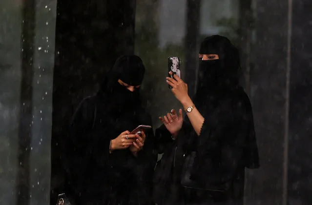Women use their mobiles during rain in Riyadh, Saudi Arabia, February 16, 2017. (Photo by Faisal Al Nasser/Reuters)