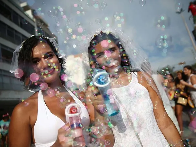 Revelers pose blowing bubbles during the “Simpatia e Quase Amor” street carnival bloco along Ipanema Beach on March 2, 2014 in Rio de Janeiro, Brazil. Carnival is the grandest holiday in Brazil, annually drawing millions in raucous celebrations. (Photo by Mario Tama/Getty Images)