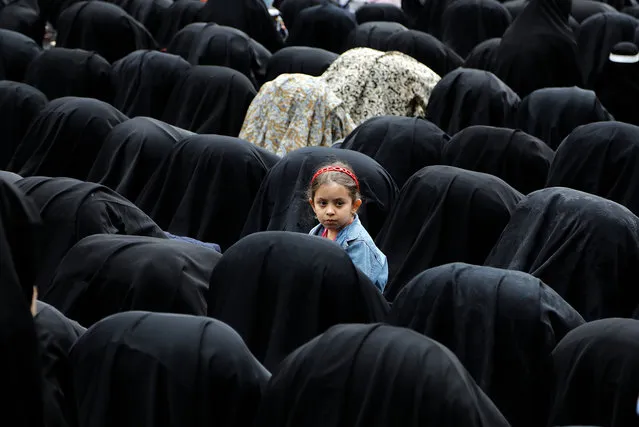 An Iranian girl watches as women pray during a mourning ceremony commemorating the death of Fatima, the daughter of Islam's Prophet Muhammad, in Tehran, Iran on March 2, 2017. Fatima was the youngest daughter of Islam's Prophet Muhammad and wife of Ali ibn Abi Talib who is regarded by Shiite Muslims as the first Imam after Prophet Muhammad. (Photo by Abedin Taherkenareh/EPA)