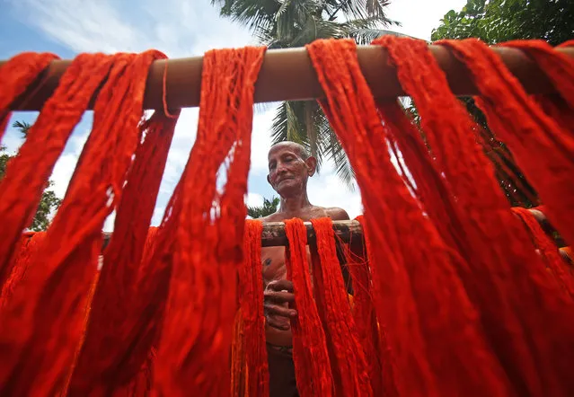 A worker hangs dyed yarns to dry at a textile mill on the outskirts of Agartala, India on July 24, 2019. (Photo by Prasanta Dey/AFP Photo)