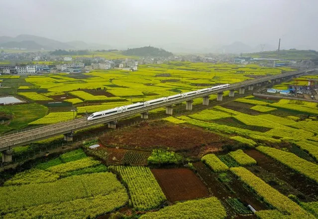 This aerial photo taken on March 16, 2017 shows a high-speed train traveling on the railway in Anshun, southwest China's Guizhou province. (Photo by AFP Photo/Stringer)