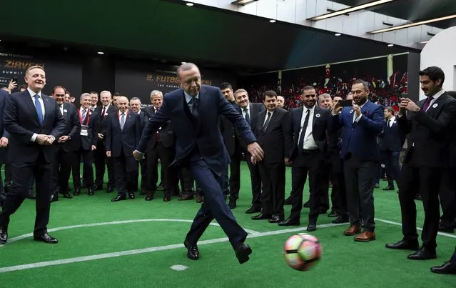 This handout photo taken and released on March 20, 2017 by Turkey's President Recep Tayyip Erdogan (C) kicks a ball, as president of the Turkish Football Federation Yildirim Demiroren (2-L) and Turkish Union of Clubs president Goksel Gumusdag (L) look on during the “Premiere Summit 2” at the Halic Congress Center in Istanbul. President Recep Tayyip Erdogan on March 20 acknowledged he was still rankled by Turkey's failure to win the right to host an Olympic Games, saying it had the ability to hold any sporting event. Istanbul was a favourite to host the 2020 Summer Games but lost out to Tokyo in the election in September 2013, a decision that still irks the Turkish strongman. (Photo by Yasin Bulbul/AFP Photo/APA/Turkish Presidential Press Service)