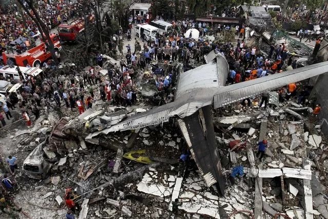 Security forces and rescue teams examine the wreckage of an Indonesian military C-130 Hercules transport plane after it crashed into a residential area in the North Sumatra city of Medan, Indonesia, June 30, 2015. (Photo by Roni Bintang/Reuters)