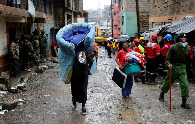 People carry their belongings as they leave the Huruma neighbourhood after a a six-storey building collapse after days of heavy rain in Nairobi, Kenya, May 1, 2016. (Photo by Thomas Mukoya/Reuters)