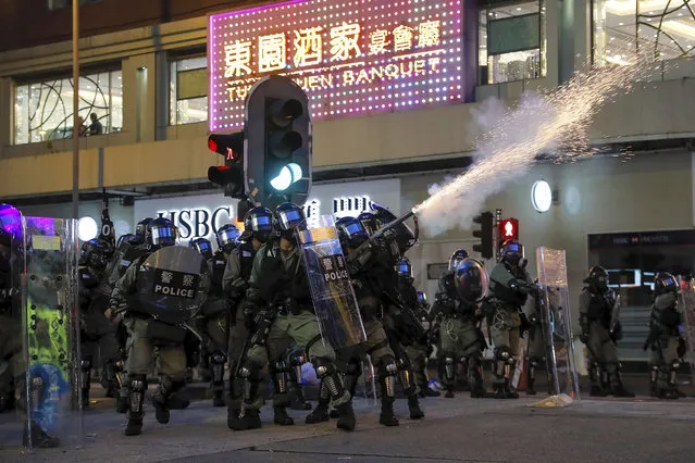 Riot police fire tear gas during the anti-extradition bill protest in Hong Kong, Sunday, August 11, 2019. (Photo by Kin Cheung/AP Photo)