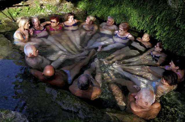 People relax in a water spring near Banja Luka, Bosnia, Tuesday, August 20, 2019. Weather forecasters predict hot weather across the country over the next few days. (Photo by Radivoje Pavicic/AP Photo)