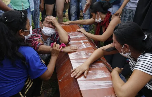 Women cry over the coffin of a relative, a victim of a deadly avalanche due to heavy rains, during a mass burial in Mocoa, Colombia, Monday, April 3, 2017. (Photo by Fernando Vergara/AP Photo)