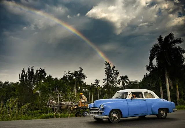 An old American car is seen in Havana as a rainbow appears in the sky, on February 3, 2022. The Cuban government on Thursday “emphatically and forcefully” demanded the end of the U.S. embargo on the island, which was reinforced “to unsuspected limits” amid the covid-19 pandemic, as it celebrates its 60th anniversary. (Photo by Yamil Lage/AFP Photo)