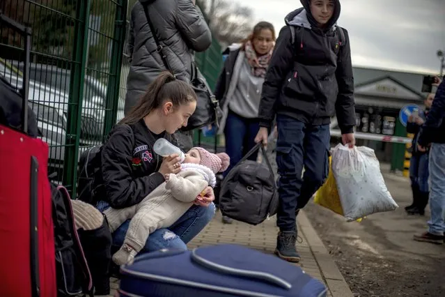 A woman feeds a child as people fleeing Ukraine arrive in Slovakia through the Ubla border crossing, 25 February 2022. Slovakia said it will let fleeing Ukrainians into the country following Russia's military operation in Ukraine. The Slovak Police Force announced on social media that people not holding a valid travel document will also be eligible for entry on an individual basis. (Photo by Martin Divisek/EPA/EFE)