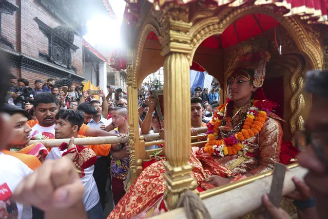 Devotees carry the chariot of living god Bhairabh during Indra Jatra festival, an eight-day festival that honors Indra, the Hindu god of rain, in Kathmandu, Nepal, Friday, September 13, 2019. (Photo by Niranjan Shrestha/AP Photo)