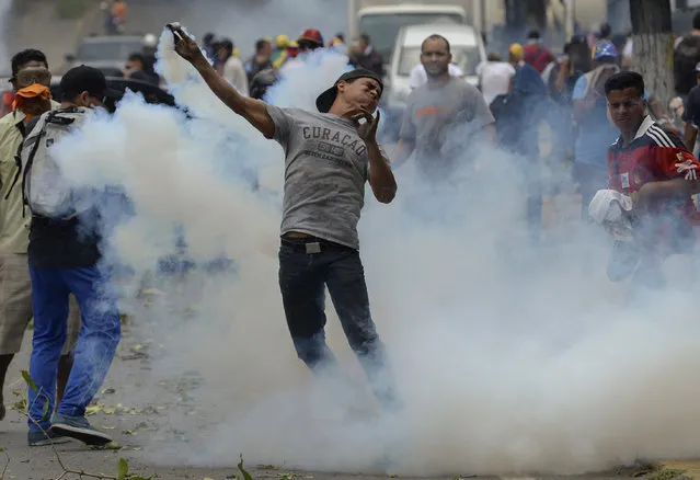 Demonstrators clash with the riot police during a protest against Venezuelan President Nicolas Maduro, in Caracas on April 20, 2017. (Photo by Federico Parra/AFP Photo)