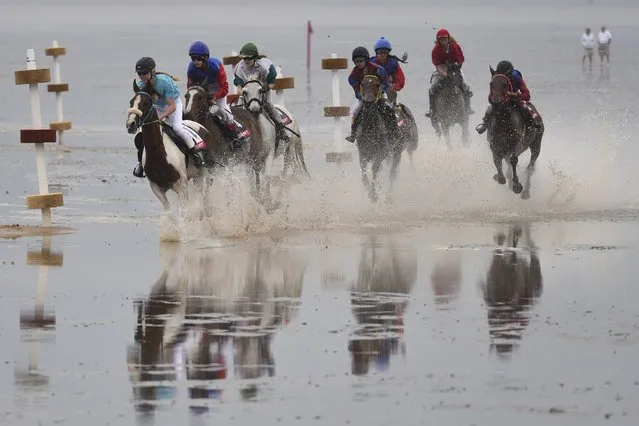 Jockeys ride horses on mud flats during their tideland race (Wadden Race) in Duhnen, Lower Saxony, Germany, July 12, 2015. (Photo by Fabian Bimmer/Reuters)