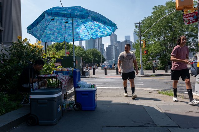 People walk through a residential area of Brooklyn on a hot afternoon on July 09, 2024 in New York City. Thousands of New Yorkers are descending to area beaches, parks, pools, and cooling centers as the city experiences its second heat wave of the summer season. (Photo by Spencer Platt/Getty Images)