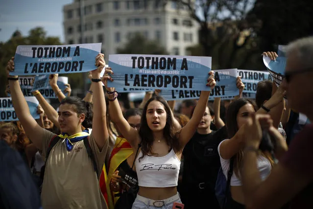 Young people hold up signs in Catalan reading “Everybody to the airport” during protests in Barcelona, Spain, Monday, October 14, 2019. Spain's Supreme Court on Monday convicted 12 former Catalan politicians and activists for their roles in a secession bid in 2017, a ruling that immediately inflamed independence supporters in the wealthy northeastern region. (Photo by Emilio Morenatti/AP Photo)