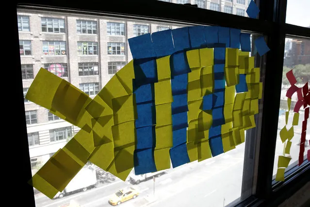 An image of a fish created with Post-it notes is seen in windows at 200 Hudson street in lower Manhattan, New York, U.S., May 18, 2016. (Photo by Mike Segar/Reuters)