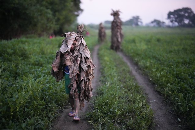 A Catholic boy walks towards the church of Saint John the Baptist during the mud festival at Bibiclat, Nueva Ecija province, northern Philippines, Monday, June 24, 2024. (Photo by Aaron Favila/AP Photo)