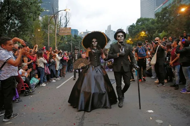 People dressed as Catrinas parade down Mexico City's iconic Reforma avenue during celebrations for the Day of the Dead in Mexico, Saturday, October 26, 2019. (Photo by Ginnette Riquelme/AP Photo)