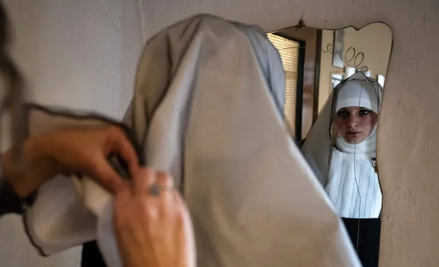 A woman dressed as a nun prepares to take part in the traditional popular and baroque funeral Easter rite known as the “Mortorio Pasquale” procession, on April 12, 2022 in Villafalletto, near Cuneo, northwestern Italy. The solemn procession dates back to 1622 and the foundation of the Confraternita della Misericordia (Brotherhood of Mercy), known as the Nera, which re-enacts it every 4 years. (Photo by Marco Bertorello/AFP Photo)