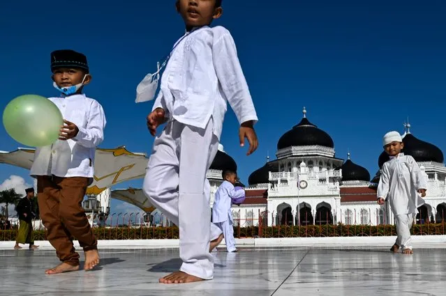 Children play on the grounds of the Baiturrahman Grand Mosque ahead of the start of Ramadan in Banda Aceh on March 30, 2022. Indonesia recently lifted restrictions to allow the resumption of traditional practises for the upcoming holy month of Ramadan after two years of tight pandemic restrictions. (Photo by Chaideer Mahyuddin/AFP Photo)
