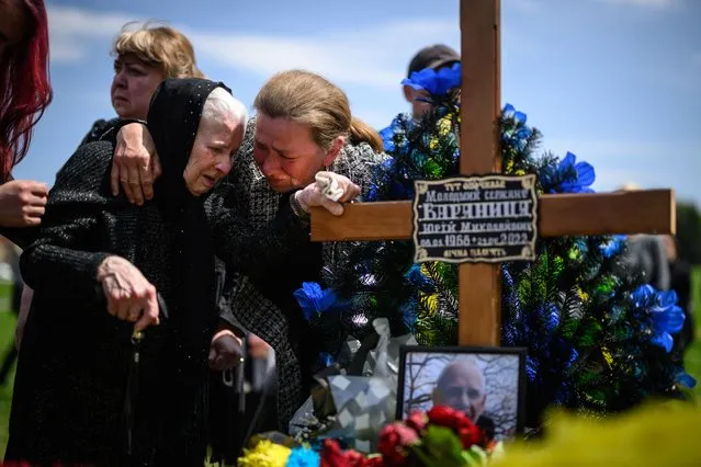 Family members mourn at the graveside of soldier Yuri Varyanytsia during the simultaneous burial of three soldiers in the Field of Mars at Lychakiv cemetery on May 06, 2022 in Lviv, Ukraine. Varyanytsia served with the 103rd Separate Brigade of the Territorial Defense Forces, and died on April 29 after coming under artillery fire in the Luhansk Region. The Ukrainian government has not released recent figures on military casualties since Russia's Feb. 24 invasion vary widely, but estimates suggest they are significantly outpaced by Russian losses. (Photo by Leon Neal/Getty Images)