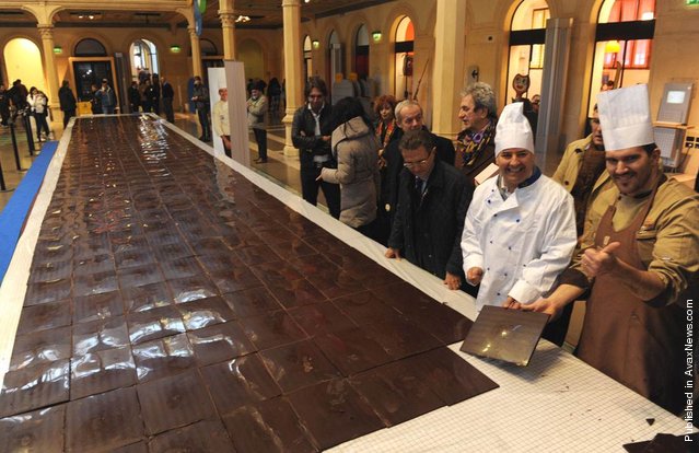 Mmmmm! Mirco Della Vecchia from Italy already holds the records for the largest chocolate sculpture and the tallest ice cream bowl. Now he's set a new record by making a 50-foot-long (15,24 m) and almost 8-feet-wide chocolate bar. It's 15,000 pounds of deliciousness