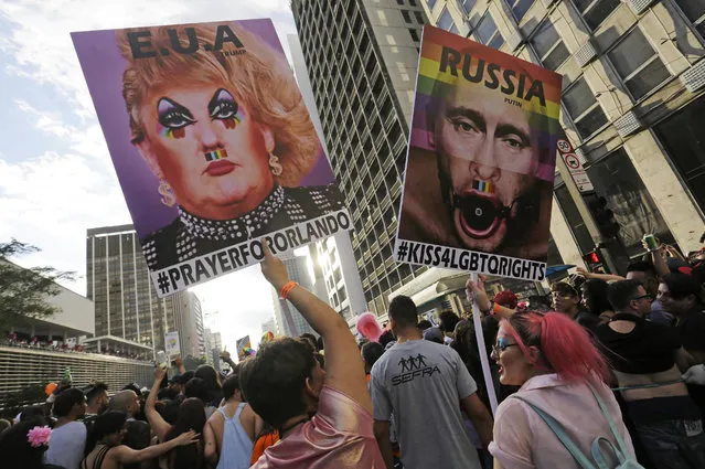 Revelers holds posters depicting United States President Donald Trump, left, and Russian President Vladimir Putin as they march during the annual Gay Pride Parade in Sao Paulo, Brazil, Sunday, June 18, 2017. (Photo by Nelson Antoine/AP Photo)