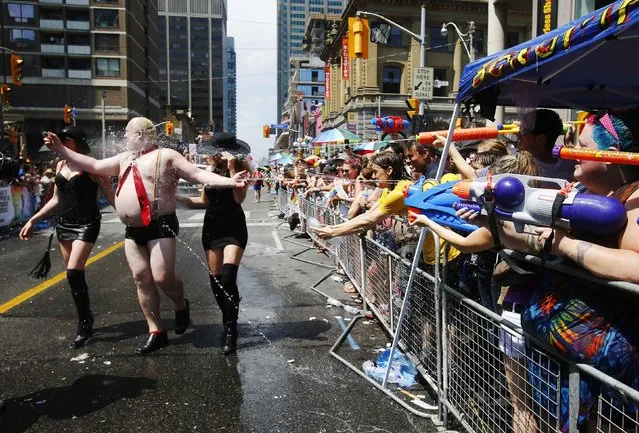 A man dressed to mock Toronto Mayor Rob Ford gets sprayed by water guns at the “WorldPride” gay pride Parade in Toronto June 29, 2014. Toronto is hosting WorldPride, a week-long event that celebrates the lesbian, gay, bisexual and transgender (LGBT) community. (Photo by Mark Blinch/Reuters)