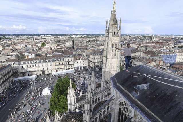 Tightrope walker and artist Nathan Paulin crosses Bordeaux on a wire from the Pey Berland Tower and the northwest spire of Saint-André Cathedral, in Bordeaux, on June 9, 2023. (Photo by Mehdi Fedouach/AFP Photo)