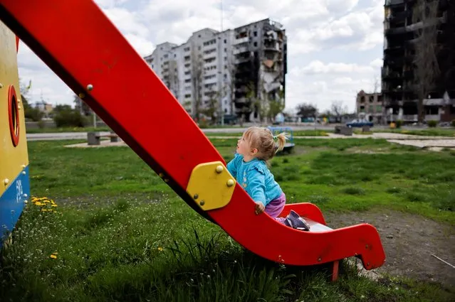 Nina Stefuryak, 2, plays at the playground in front of a building, destroyed by shelling, amid the Russian invasion of Ukraine, in Borodianka, Kyiv region, Ukraine, May 2, 2022. (Photo by Zohra Bensemra/Reuters)