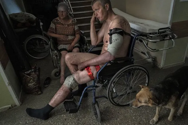 A Ukrainian injured serviceman and an injured civilian wait for medical treatment in the Donetsk region, eastern Ukraine, Tuesday, June 7, 2022. (Photo by Bernat Armangue/AP Photo)