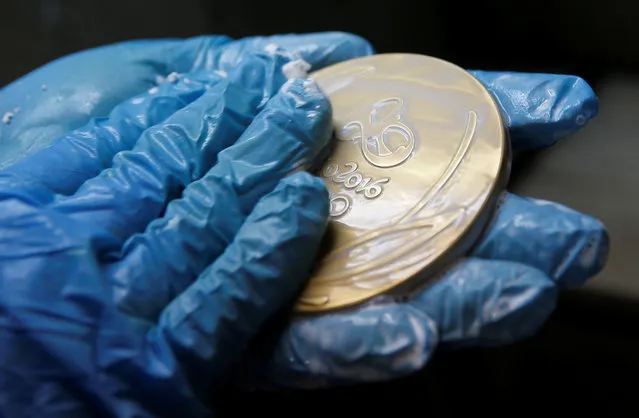 A worker from the Casa da Moeda do Brasil (Brazilian Mint) cleans a Rio 2016 Olympic medal in Rio de Janeiro, Brazil, June 28, 2016. (Photo by Sergio Moraes/Reuters)