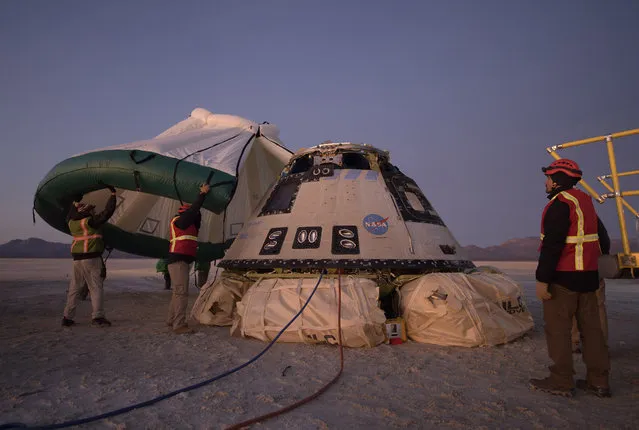 In this Sunday, December 22, 2019 photo made available by NASA, Boeing, NASA, and U.S. Army personnel work around the Boeing Starliner spacecraft shortly after it landed in White Sands, N.M. On Friday, Feb. 7, 2020, NASA said defective software could have doomed the crew capsule during its first test flight that ended up being cut short. (Photo by Bill Ingalls/NASA via AP Photo)