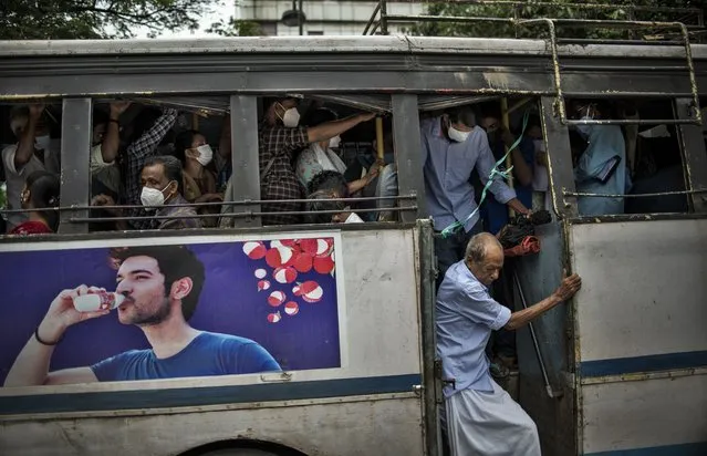 A man without a mask alights from a crowded bus in Kochi, Kerala state, India, Wednesday, July 6, 2022. The southern state has made wearing masks mandatory in public places in the wake of rise in COVID-19 cases. (Photo by R.S. Iyer/AP Photo)