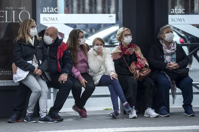 People wait at a bus stop, in Rome, Monday, March 9, 2020. Italy announced a sweeping quarantine early Sunday for its northern regions, igniting travel chaos as it restricted the movements of a quarter of its population in a bid to halt the new coronavirus' relentless march across Europe. (Photo by Roberto Monaldo/LaPresse via AP Photo)