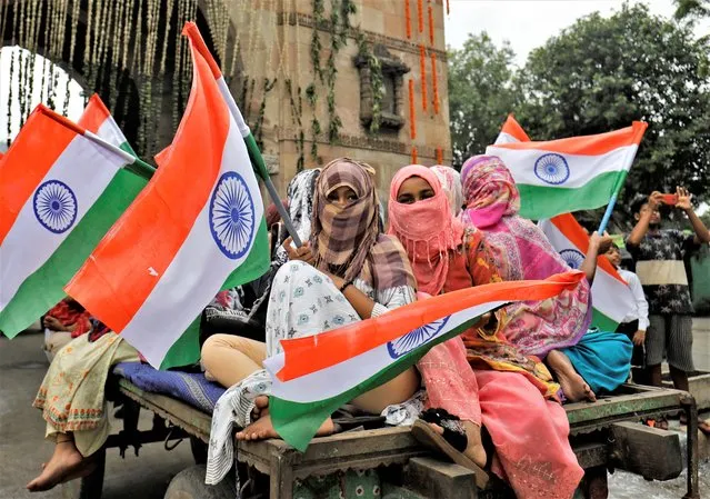 Women wave national flags as they take part in India's Independence Day celebrations in Ahmedabad, India, August 15, 2022. (Photo by Amit Dave/Reuters)