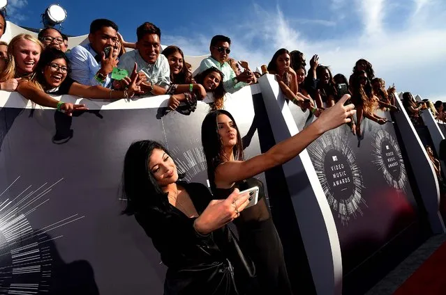 Models Kylie Jenner and Kendall Jenner take selfies at the 2014 MTV Video Music Awards at The Forum in Inglewood, California, on August 24, 2014. (Photo by Larry Busacca/Getty Images for MTV)
