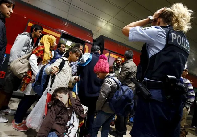 A German border police woman reacts after dozens of migrants unexpectedly disembarked a train that departed from Budapest's Keleti station at the railway station of the airport in Frankfurt, Germany, early morning September 6, 2015. Austria and Germany threw open their borders to thousands of exhausted migrants on Saturday, bussed to the Hungarian border by a right-wing government that had tried to stop them but was overwhelmed by the sheer numbers reaching Europe's frontiers. (Photo by Kai Pfaffenbach/Reuters)