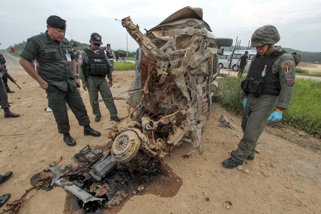 Military personnel stand next to a damaged military vehicle where soldiers were attacked by suspected Muslim militants at Muang district in the southern province of Yala, Thailand, September 14, 2015. Five soldiers were injured, according to local media. (Photo by Surapan Boonthanom/Reuters)