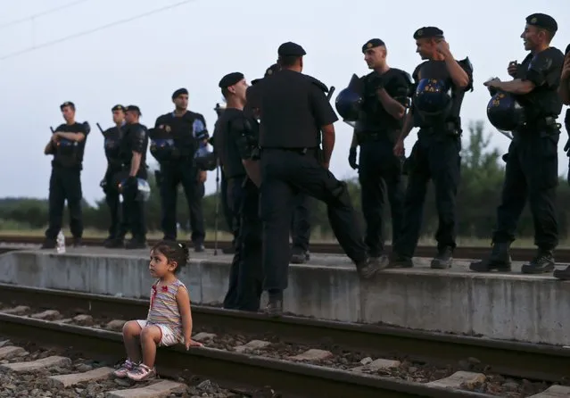 A migrant child sits on railway tracks at a train station in Tovarnik, September 18, 2015. (Photo by Antonio Bronic/Reuters)
