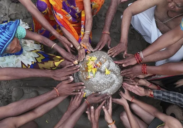 Hindu devotees perform rituals in the Sangam, the confluence of the Rivers Ganges, Yamuna and the mythical Sarawati, during a partial solar eclipse in Prayagraj, in the northern state of Uttar Pradesh, India, Tuesday, October 25, 2022. The partial solar eclipse or Surya Grahan on Oct. 25 marks the last solar eclipse of the year. (Photo by Rajesh Kumar Singh/AP Photo)