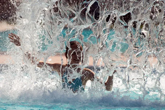 A girl under a fountain at the outdoor pool in Neuzelle, Germany, 25 August 2016 as the high temperatures continue across Europe. (Photo by Patrick Pleul/EPA)