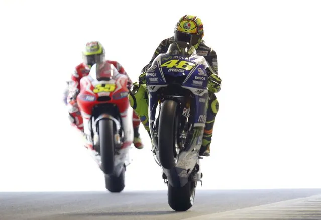Yamaha MotoGP rider Valentino Rossi (R) of Italy and Ducati MotoGP rider Cal Crutchlow of Britain perform wheelies at the end of a free practice session for Sunday's Japanese Grand Prix at the Twin Ring Motegi circuit in Motegi, north of Tokyo October 11, 2014. (Photo by Toru Hanai/Reuters)