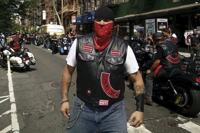 A motorcycle enthusiast blocks access to East 3rd St as a large group of motorcycles gather at the Hell's Angels clubhouse in the Manhattan borough of New York, August 23, 2015. (Photo by Carlo Allegri/Reuters)