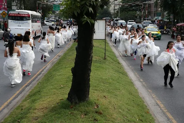 Brides run along the roadway during the вЂњRunning of the BridesвЂќ race, in Bangkok, Thailand, December 2, 2017. (Photo by Athit Perawongmetha/Reuters)